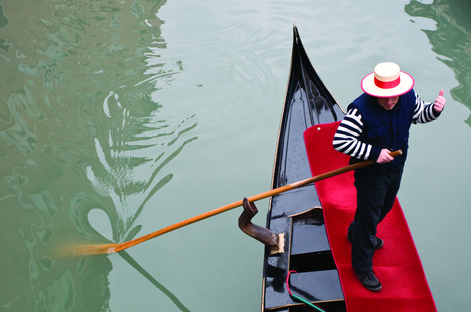 A gondolier gives a few explanations to his customers during a gondola ride