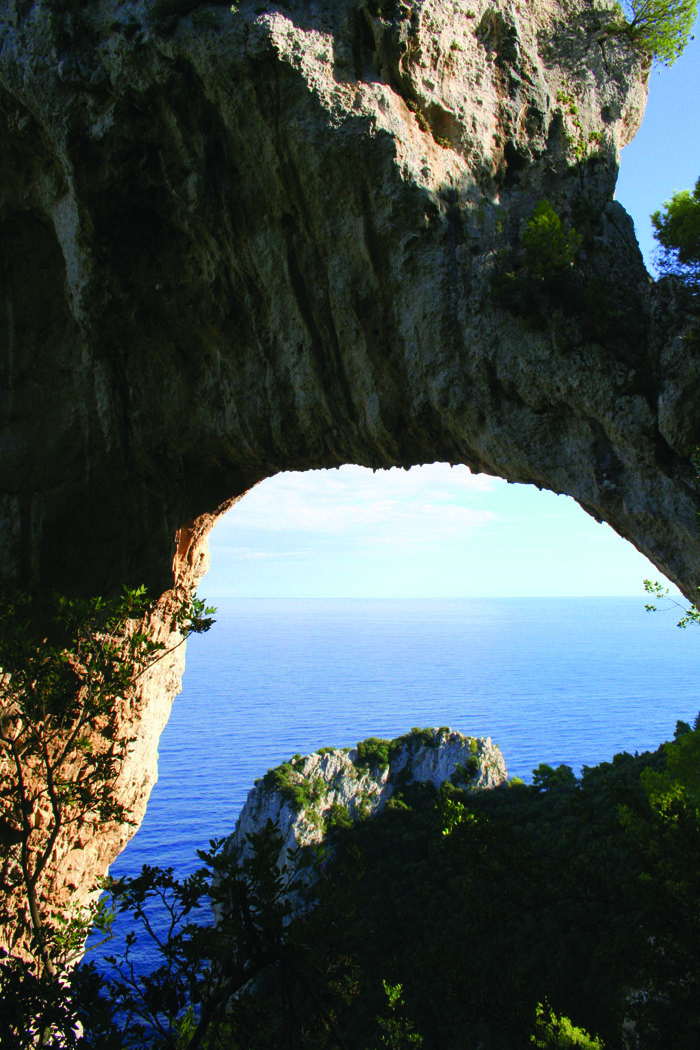Natural arch climbing from the sea 