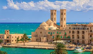 View of Molfetta old town: the harbor and the Old Cathedral of St. Conrad (Duomo Vecchio of San Corrado).ITALY(Apulia).Old Cathedral of Molfetta in Romanesque style:church with three domes aligned with side half-barrels.