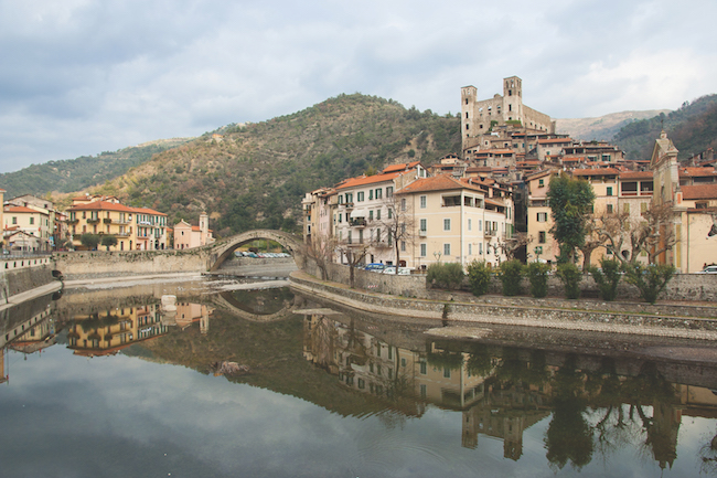 View of Dolceacqua medieval village. The famous roman humpback bridge and Doria castle reflecting in Nervia river