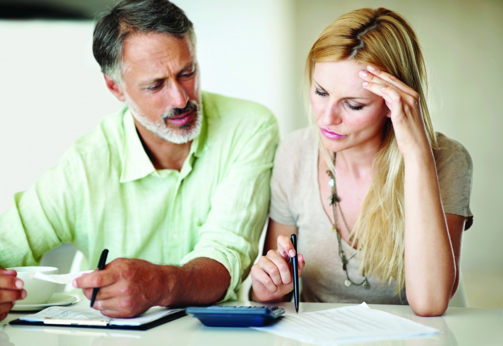 Tensed Caucasian woman and man calculating home finances