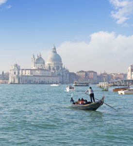 Gondola full of tourists, with Santa Maria della Salute in the background