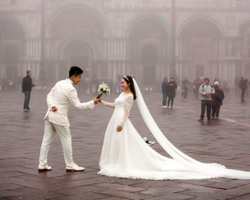 A couple in bridal wear on a Venetian street