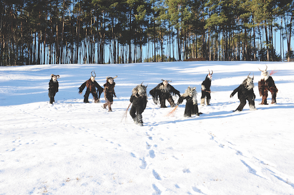 Men dressed as Krampus in a snowy field just outside Castelrotto, South Tyrol, Italy