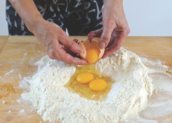 cracking eggs into flour