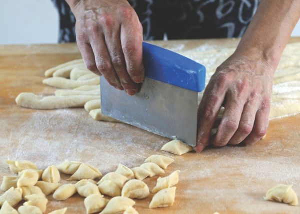 cutting each sausage into individual gnocchi