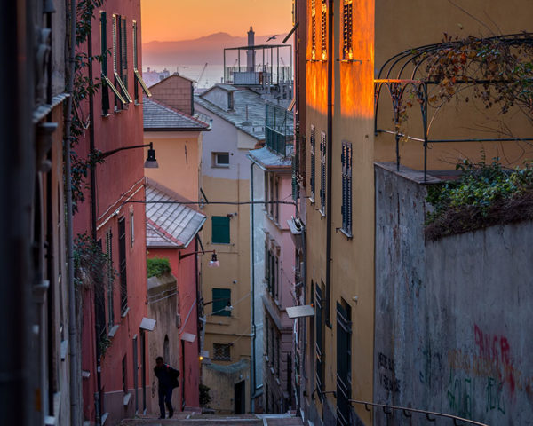 Narrow alleyways in Genoa with colourful buildings and warm sunset