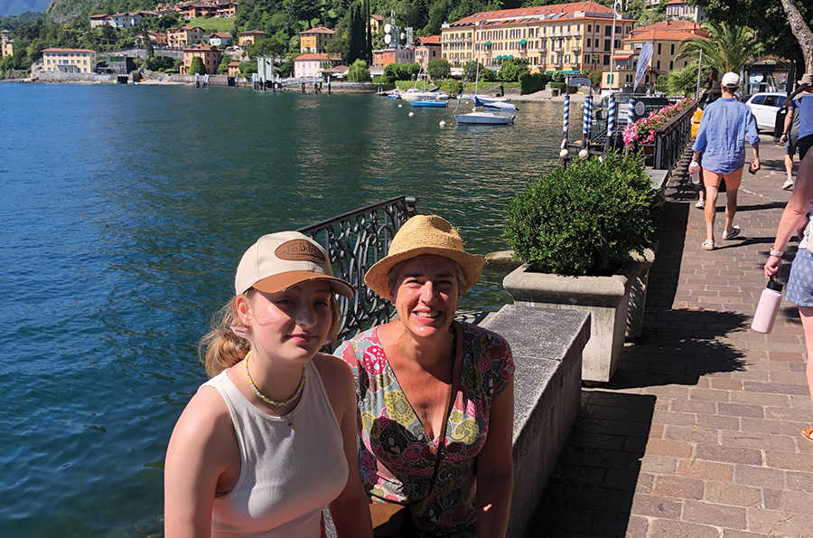 Lorenza and her daughter sat on a wall lakeside in Menaggio