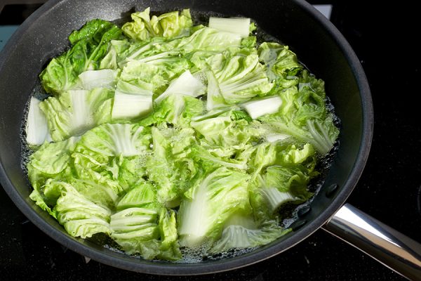 cabbage being boiled in a pan