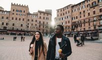 Couple walking in plaza in Siena with gelato