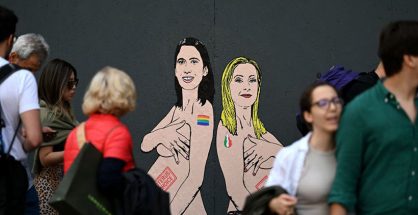 Pedestrians look at a mural painting made by Italian artist and activist aleXsandro Palombo, depicting Prime Minister Giorgia Meloni (R) and Democratic Party (PD) Secretary Elly Schlein (L) naked and pregnant in reference to the ongoing debate over surrogacy in the country