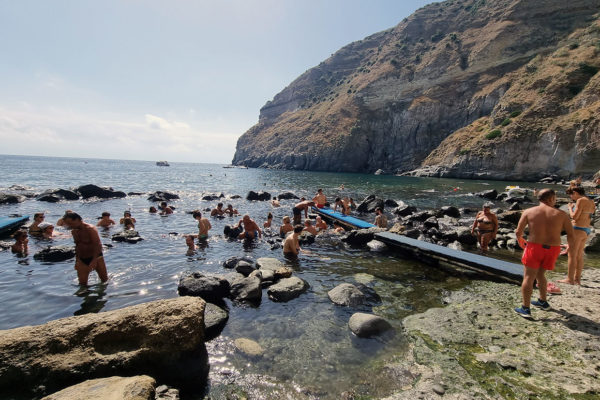 people in the rocky springs at Baia di Sorgeto