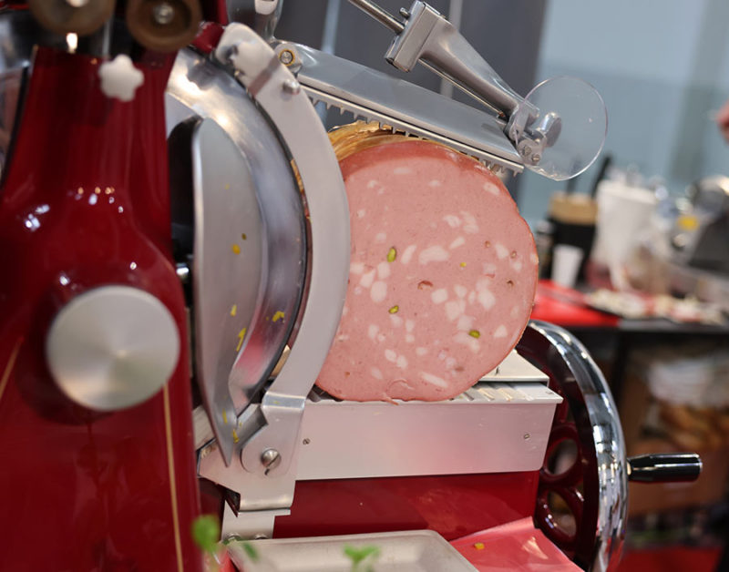 Mortadella ready to be cut on a professional slicer