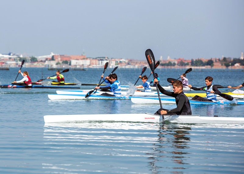 Children rowing in kayaks on family holidays in venice