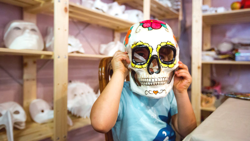 Family holidays venice child in venetian skull mask in paint your own workshop italy