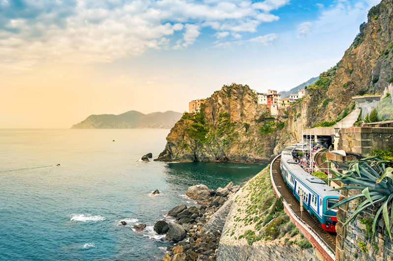 Train on cliff by sea in cinque terre