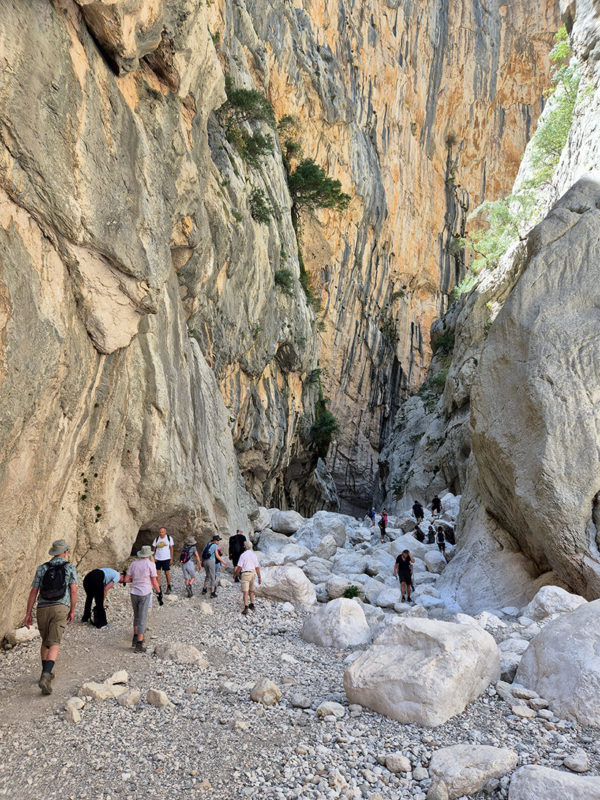 People walking in deep canyon in Sardinia