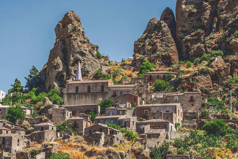 Pentedattilo abandoned village in calabria with five fingers rock formation above