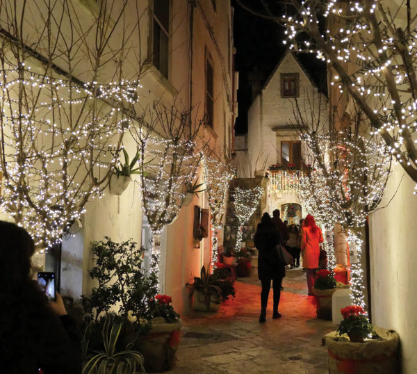a quiet street with christmas decorations. Typical locorotondo house with tall, pointed roof in background