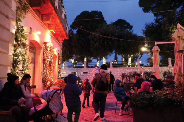 People starting to move from seats in warm glow of christmas lights