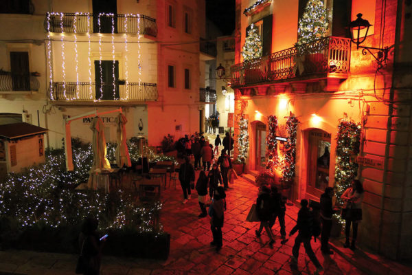 People walking in festive village in Puglia