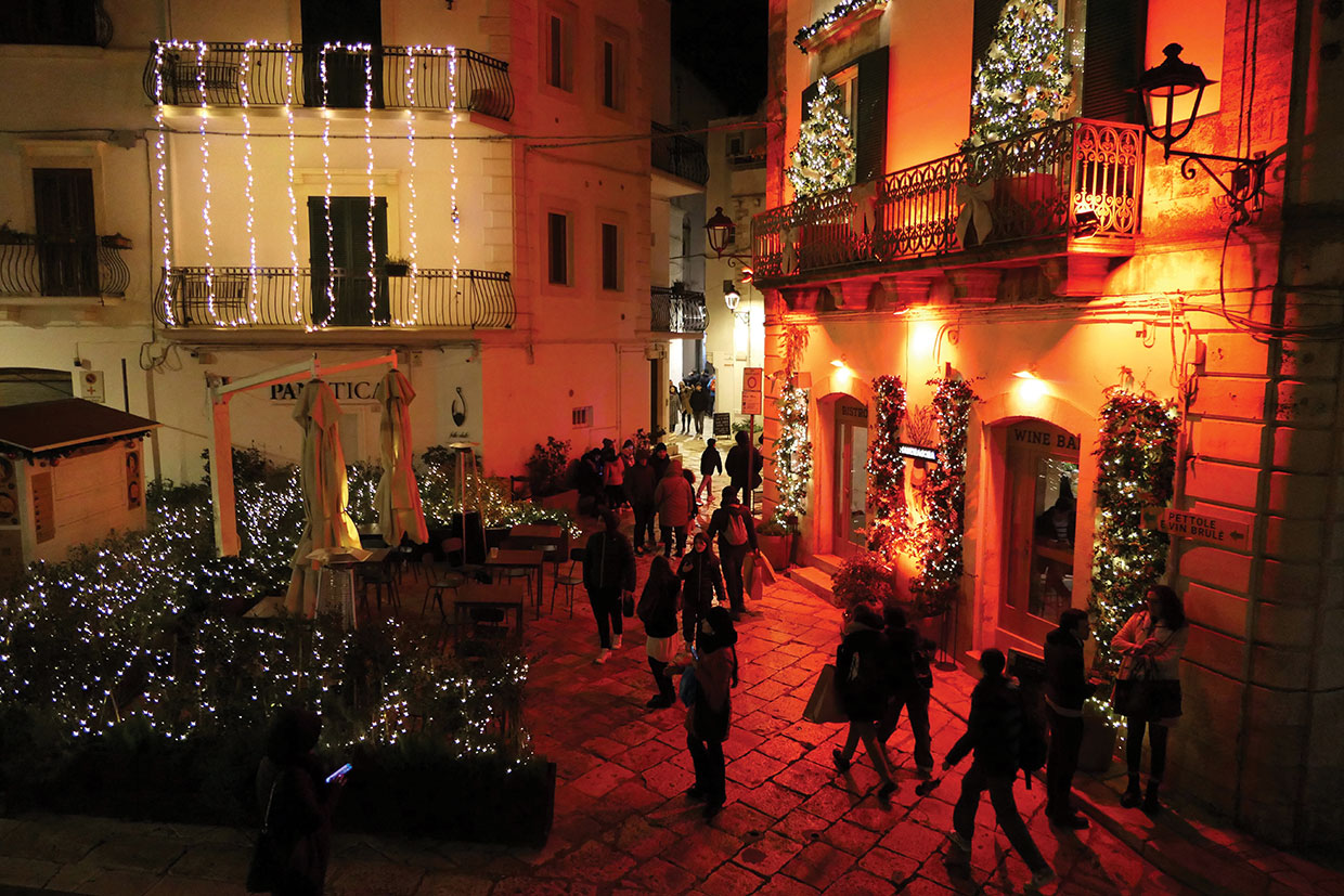 People walking in festive village in Puglia