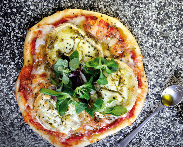 Goat’s cheese and pesto pizza with salad leaves