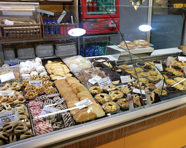 glass cabinet of indoor market stall with cakes and bakery items