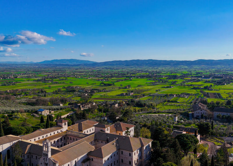 Aerial view of the rural countryside and olive groves surrounding Assisi in Umbria