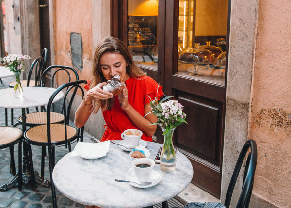 albergo diffuso: woman eating croissant at local cafe