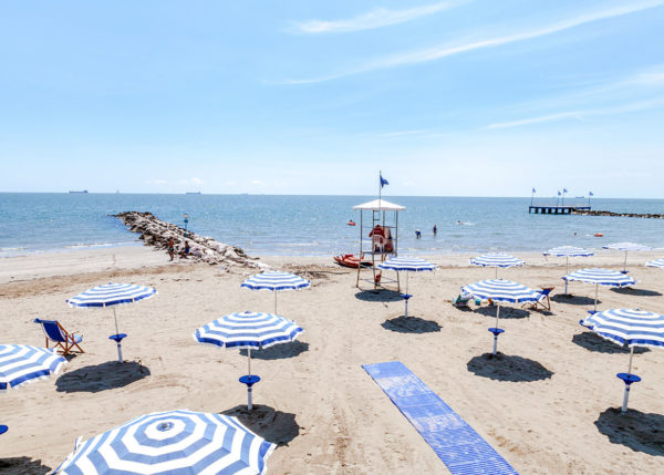 blue striped parasols on the beach in Lido di Venezia
