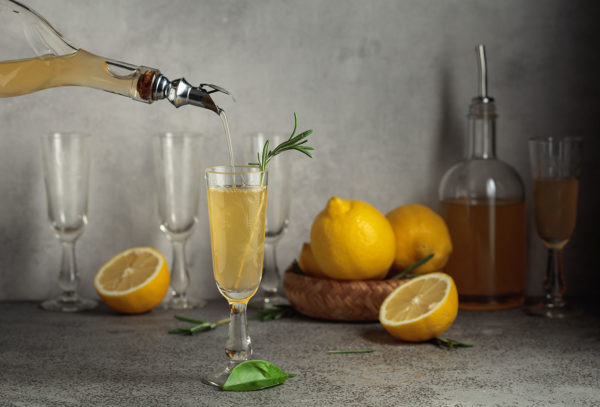 Italian liqueur Limoncello with fresh lemons and rosemary branches